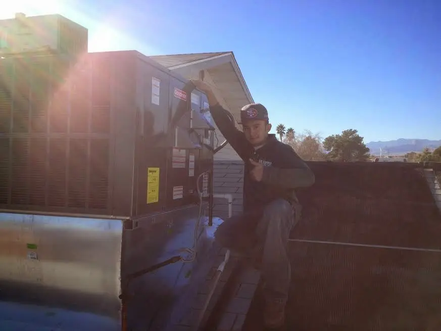 HVAC technician performing Air Duct Cleaning on a rooftop unit in West Deer